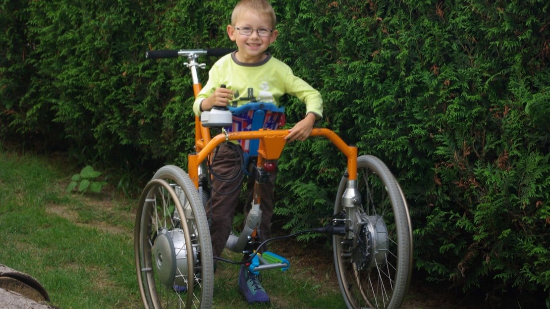 Nolann avec le déambulateur à assistance électrique inventé par son père, gagnant du premier prix du public en 2018; }}